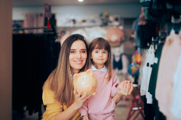 Mother and Daughter Holding a Piggy Bank Standing in a Shop. Happy family saving money during sale season buying within their budget
