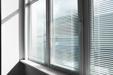 Stylish window with horizontal blinds in room