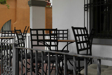 Chairs at tables on terrace near cafe