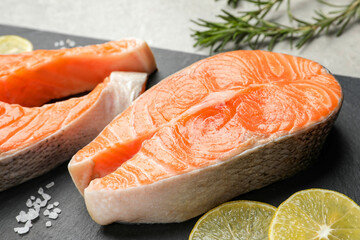 Fresh salmon and ingredients for marinade on black board, closeup