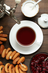 Flat lay composition with delicious ring shaped Sushki (dry bagels) and cup of tea on wooden table