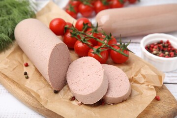 Delicious liver sausages and other products on white wooden table, closeup