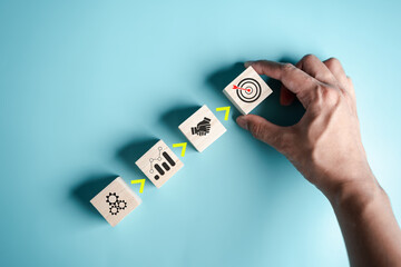 Step to success of hand arranges a wooden block with business target icon. planning business...