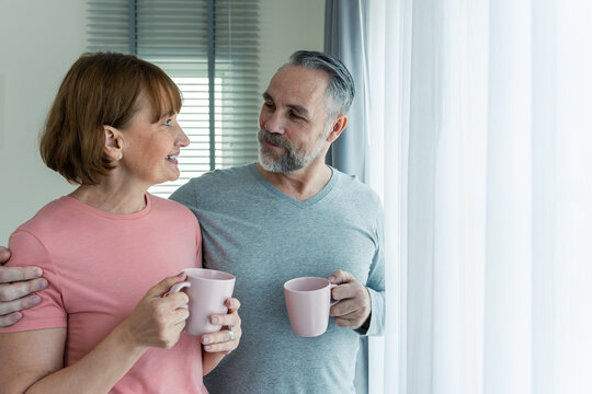 Caucasian Senior Older Couple Hugging Each Other In Bedroom At Home. 