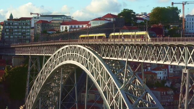 Tram crossing famous Dom Luis bridge, Ponte dom Luis above old town of Porto at river Duoro, Portugal.