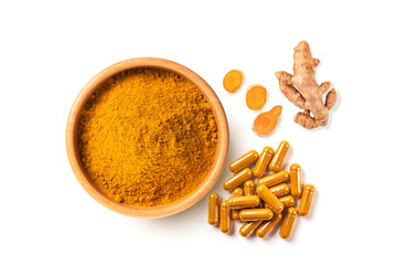 Top view of Turmeric powder in wood bowl , capsule ,root slice on white background.
