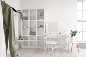 Interior of light makeup room with table and shelving unit