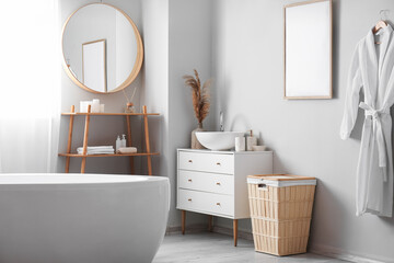 Interior of light bathroom with drawers, shelving unit and basket