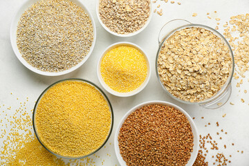 Bowls of different cereals on light background