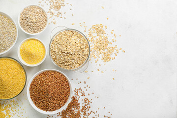 Bowls of different cereals on light background