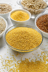 Bowls of different cereals on light background, closeup