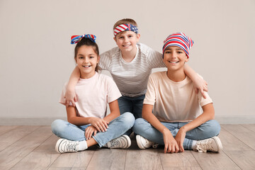 Happy little friends sitting near grey wall