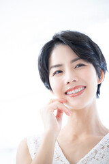 春夏の美容に使いやすいスキンケア効果を実感する美しい女性　アップ　見上げる　縦