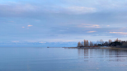 Beautiful view of the amazing mountain lake at sunset. The pearl of Kyrgyzstan is Lake Issyk-Kul. Calm calming natural background.