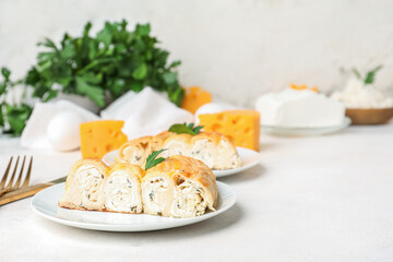 Plate with piece of delicious cheese pie and parsley leaf on white table