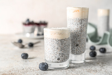 Shots of delicious pudding with chia seeds and blueberries on white table, closeup