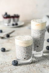 Shots of delicious pudding with chia seeds and blueberries on white table, closeup