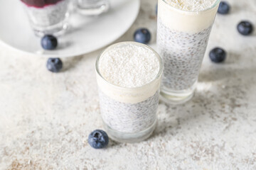 Shots of delicious pudding with chia seeds and blueberries on white table, closeup