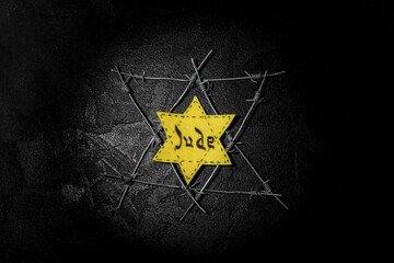 Jewish badge and barbed wire on black background. International Holocaust Remembrance Day