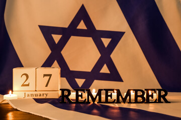 Calendar with date 27 JANUARY, word REMEMBER and burning candles on flag of Israel. International...