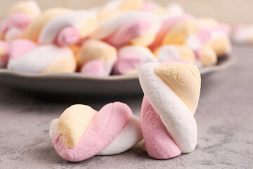 Delicious twisted marshmallows on grey table