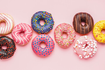 Tasty glazed donuts on pink background, closeup