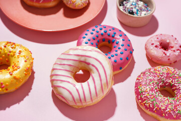 Tasty glazed donuts on pink background, closeup