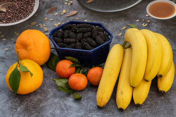 Orange, tangerine, mulberries, banana. Orange, yellow, black colors. Food market.