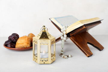 Lantern with Koran and treats on white background. Islamic New Year celebration