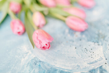 A bouquet of pink fresh tulips lies on a blue and turquoise scenic art background. Abstract blue art background. Fragment of artwork. Contemporary art. Oil paint Valentine's Day Background 