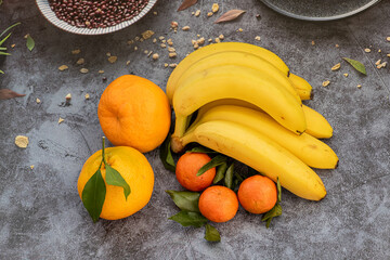 Bananas, mandarines on stone table. Ripe fruit on the stone table. juicy fruits on stone background