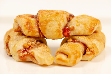 Rugelach cookies are made on cream cheese dough with strawberry jam, and mixed nuts topped with cinnamon sugar. 