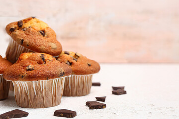 Delicious muffins with chocolate on white table