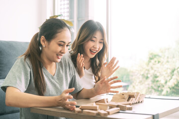 Young adult southeast asian couple relax lifestyle playing jenga board game at home