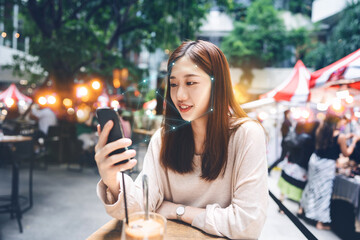 Young adult asian woman using mobile phone for face detection identity scan