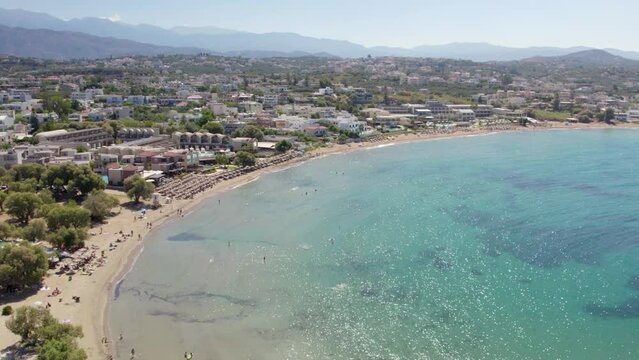 Panoramic View Of A Crystal Clear Beach In Tropical Resort Of Chania Town, Crete Island, Greece. Aerial Drone Shot