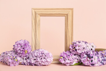 Composition with empty picture frame and beautiful hyacinth flowers on color background