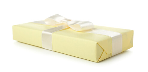 Gift box wrapped in yellow paper with silk ribbon on white background