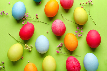 Composition with painted Easter eggs and gypsophila flowers on green background