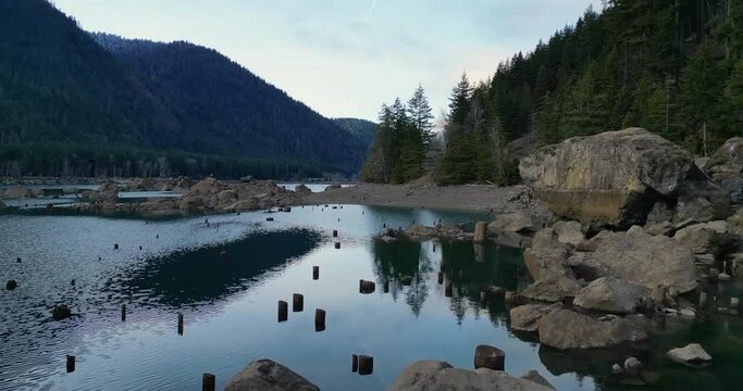 Fly by Cushman Rock then pans towards Timber Mountain. Great rocks and lake reflections at sunset.
