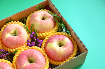 beautiful pink apple in the box on green background
