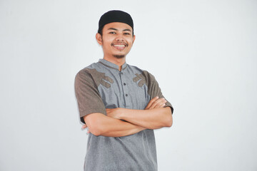 smile or happy young asian muslim man crossed arms and looking camera wearing grey koko clothes isolated on white background