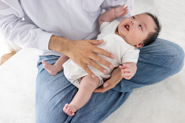 Obraz premium 赤ちゃんをあやす男性の手（0歳2ヶ月・日本人・男の子）