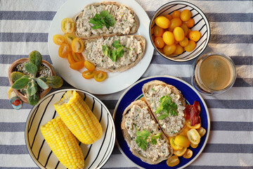 Healthy breakfast, toasted bread with tuna, corn and cherry tomatoes, top view