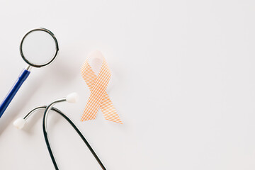 Pink awareness ribbon sign and stethoscope of International World Cancer Day campaign month isolated on white background with copy space, concept of medical and health care support, 4 February