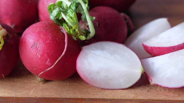 Fresh red radish bundle on chopping board on table 