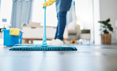 Housekeeping, cleaning and woman maid with a mop to clean the living room floor at a house. Female...