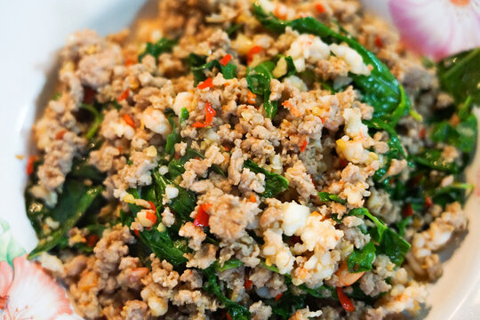 Minced pork and shrimp stir fried with green basil leaves and red hot chili with garlic, a famous Thai spicy dish called Phat Kraprao, usually homecook or order at streetfood or restaurant