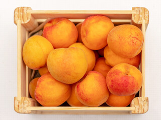 Ripe delicious apricots in a wooden box outdoors