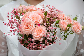 A bouquet of pink roses in the hands of a girl